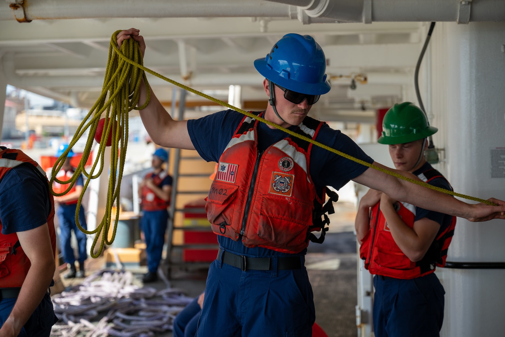 Seaman Tristan Morrow, a crewmember aboard U.S. Coast Guard Cutter Polar Star (WAGB 10), makes up a heaving line mooring station while the Polar Star prepares to depart Royal Australian Naval Base HMAS Kuttabul in Sydney, Dec. 27, 2024. The Polar Star stopped in Sydney on its way to Antartica in support of Operation Deep Freeze, a joint service, inter-agency support operation for the National Science Foundation, which manages the United States Antarctic Program.  (U.S. Coast Guard photo by Petty Officer 2nd Class Briana Carter)