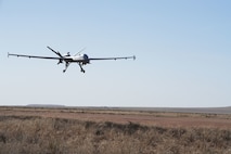 An MQ-9 Reaper prepares to land on a dirt strip