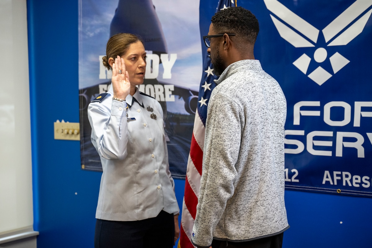 Maj. Micah D. Bluto, 351st Recruiting Squadron commander, conducts the Oath of Enlistment with Trakeius Battle, a new recruit, at the Duluth, Georgia, recruiting office.