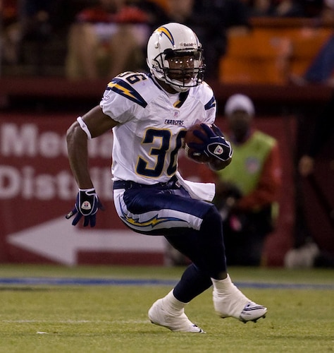 Trakeius Battle, a former National Football League player with the San Diego Charges runs a football down the field during a game.