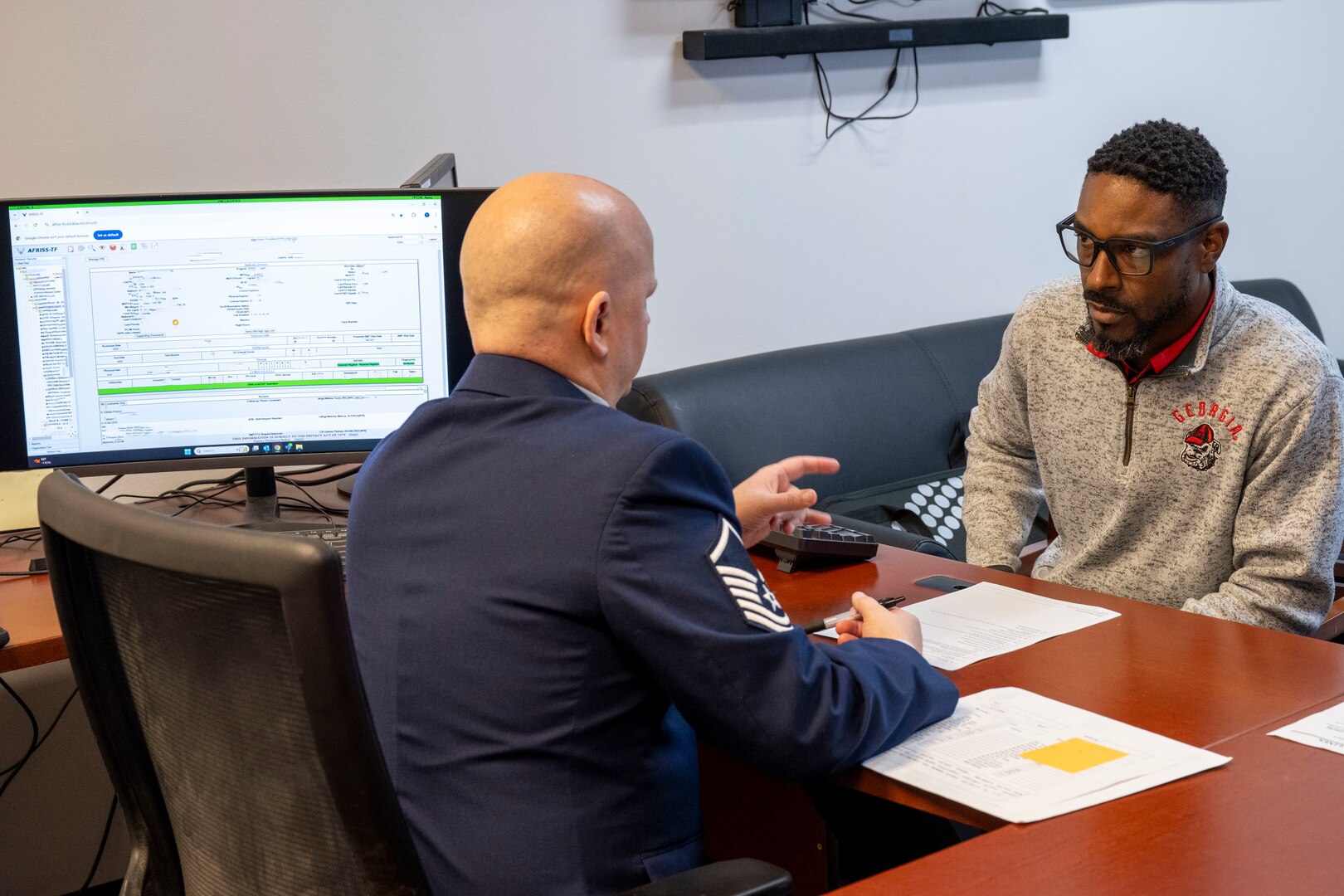 Master Sgt. Travis Whitton, an enlisted accessions recruiter assigned to the 351st Recruiting Squadron, Dobbins Air Reserve Base, Georgia, reviews enlistment documentation with Trakeius Battle, a new recruit, prior to taking his Oath of Enlistment