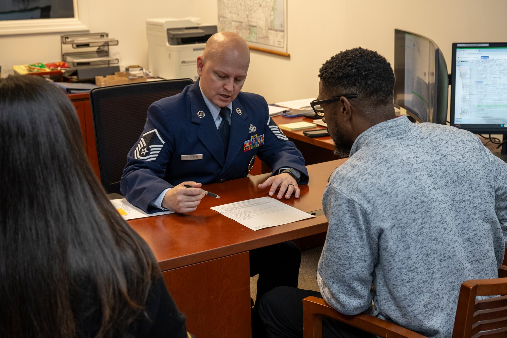 Master Sgt. Travis Whitton, an enlisted accessions recruiter assigned to the 351st Recruiting Squadron, Dobbins Air Reserve Base, Georgia, reviews enlistment documentation with Trakeius Battle, a new recruit, prior to taking his Oath of Enlistment