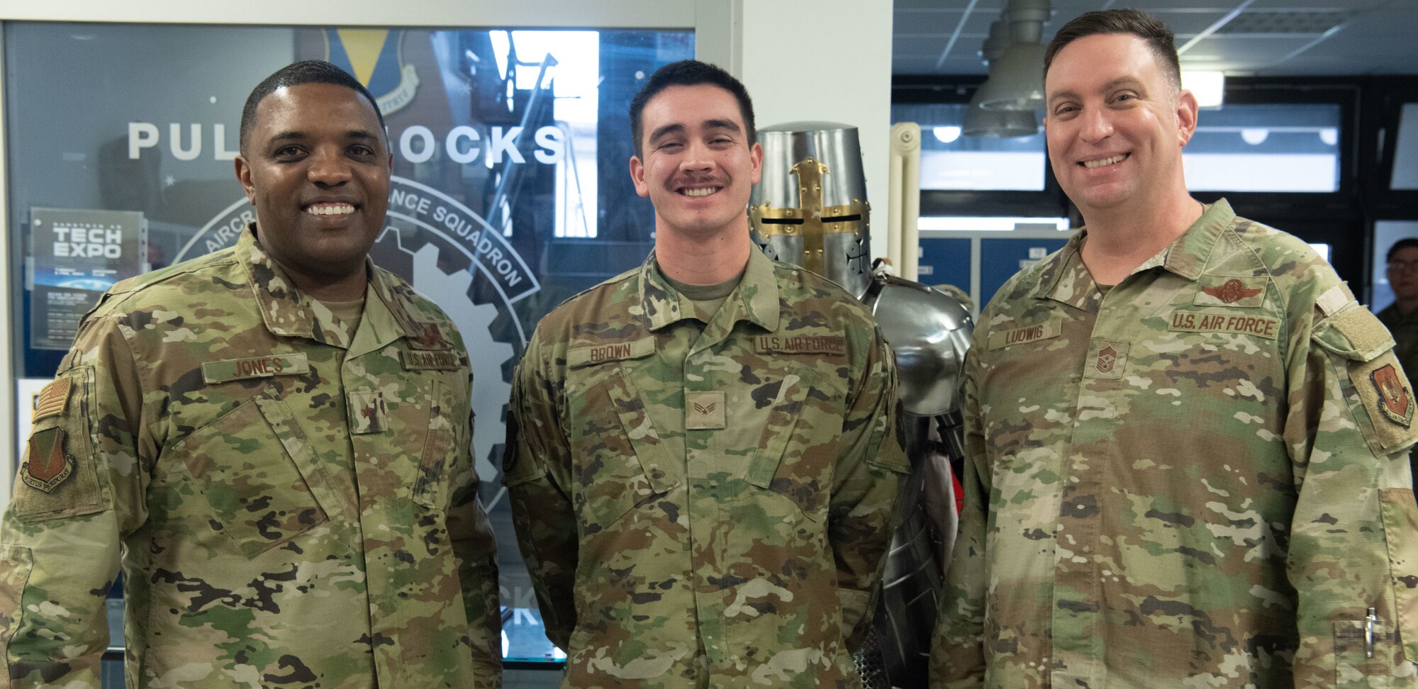 Three men pose for a photo.