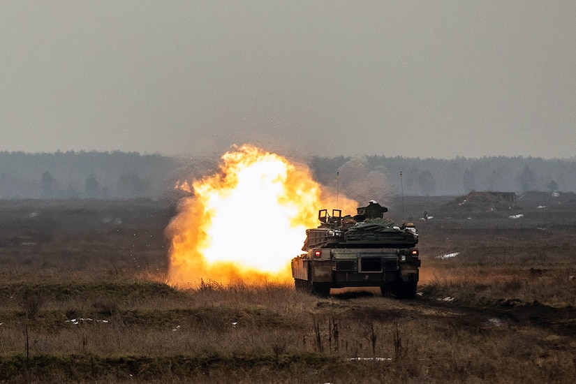 A fireball erupts from a tank on a field.