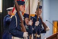 A photo of four Honor Guard members presenting the colors.