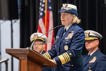 A photo of a woman speaking on stage.