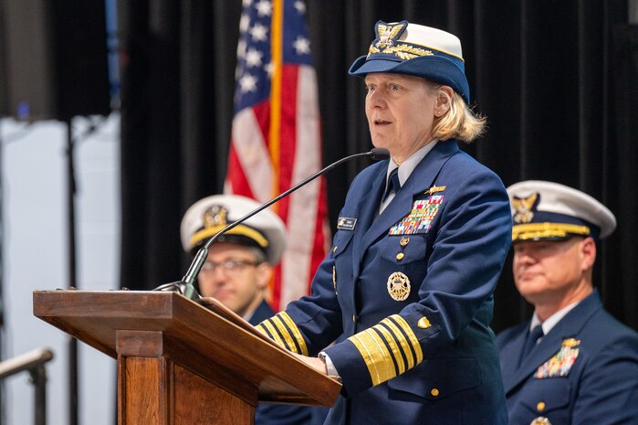 A photo of a woman speaking on stage.