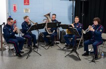 A photo of U.S. Coast Guard Band members playing their instruments.