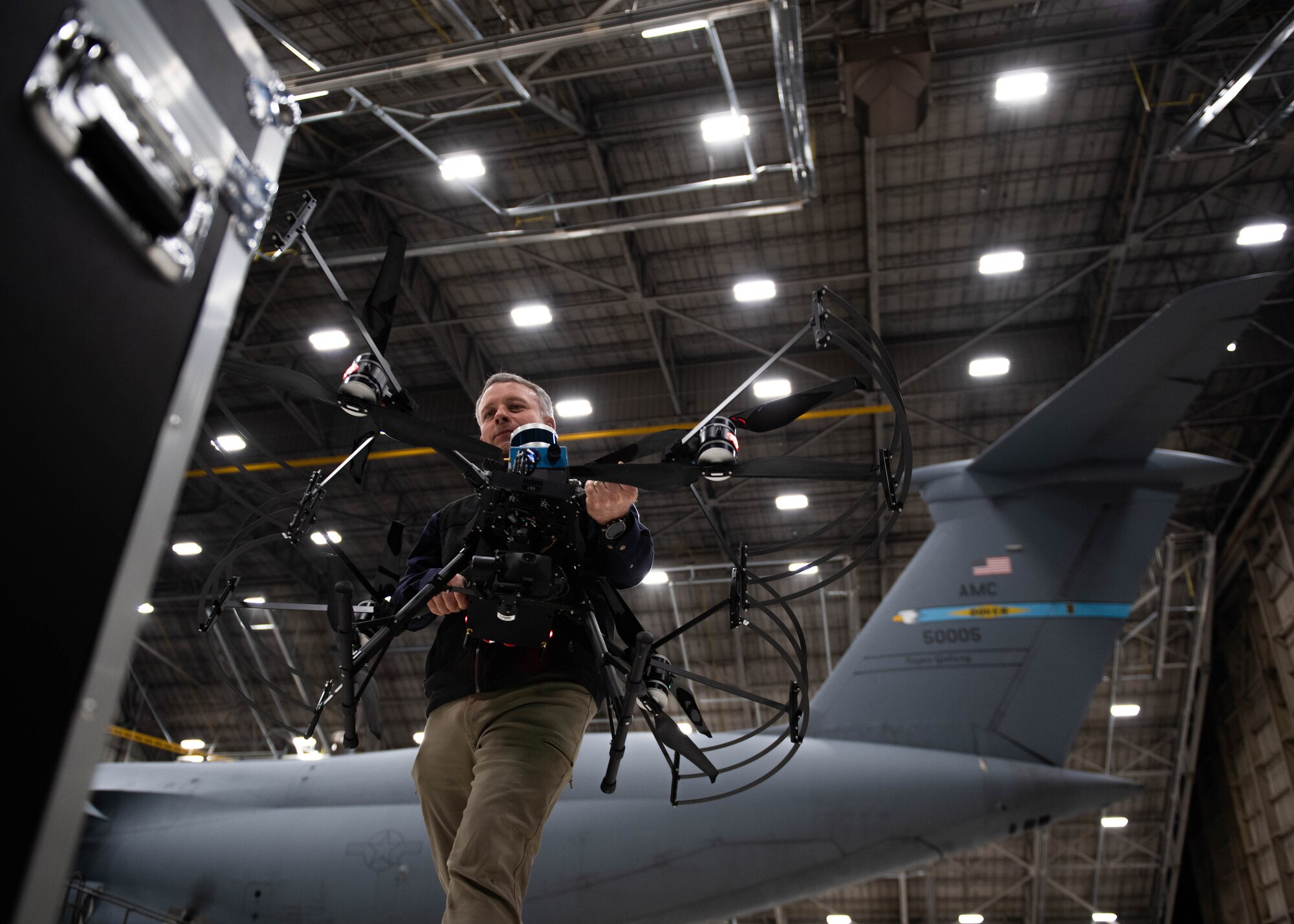 David Murphy, Near Earth Autonomy test pilot, carries a drone after a demonstration at Dover Air Force Base, Delaware, January 23, 2024. Team Dover in cooperation with Boeing and Near Earth Autonomy tested a drone program for an autonomous C-5M Super Galaxy aircraft inspection project. Traditional inspections that require personnel to use a safety harness, maintenance stands, or vehicles can take hours to accomplish, but the drone can complete the same inspection in approximately 10 minutes. (U.S. Air Force photo by Tech. Sgt. J.D. Strong II)