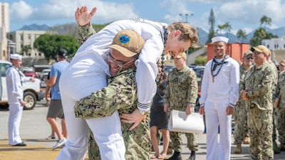TM2 Phillip Rosales hugs TM2 Kyle Purser during a homecoming celebration for USS North Carolina (SSN 777) at Joint Base Pearl Harbor-Hickam.