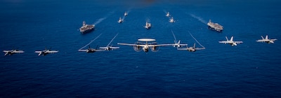 Aircraft from Carrier Airwing Two fly in formation over the Carl Vinson and Theodore Roosevelt Carrier Strike Groups during Multi-Large Deck Event.