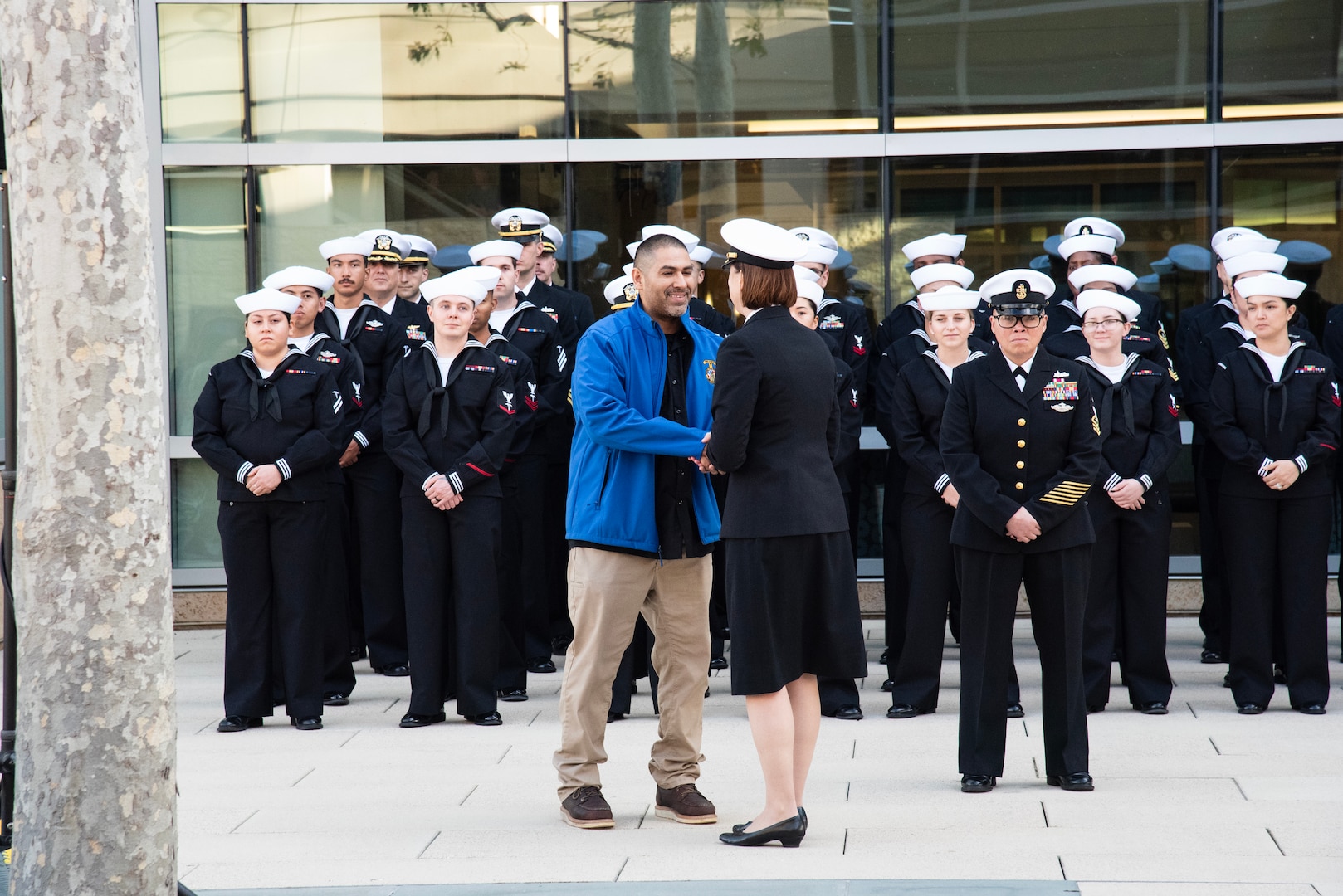 Navy Capt. Jenny Burkett, director of Naval Hospital Camp Pendleton, presents Mr. Jason Obregon with a command coin during a celebration of the 10-Year Anniversary of the grand opening of the current Naval Hospital Camp Pendleton held aboard Marine Corps Base Camp Pendleton on Jan. 30, 2024. Obregon was one of the first hospital staff members to set foot in the new hospital to prepare for the arrival of staff and equipment from the previous facility in the Lake O’Neill area of the base.