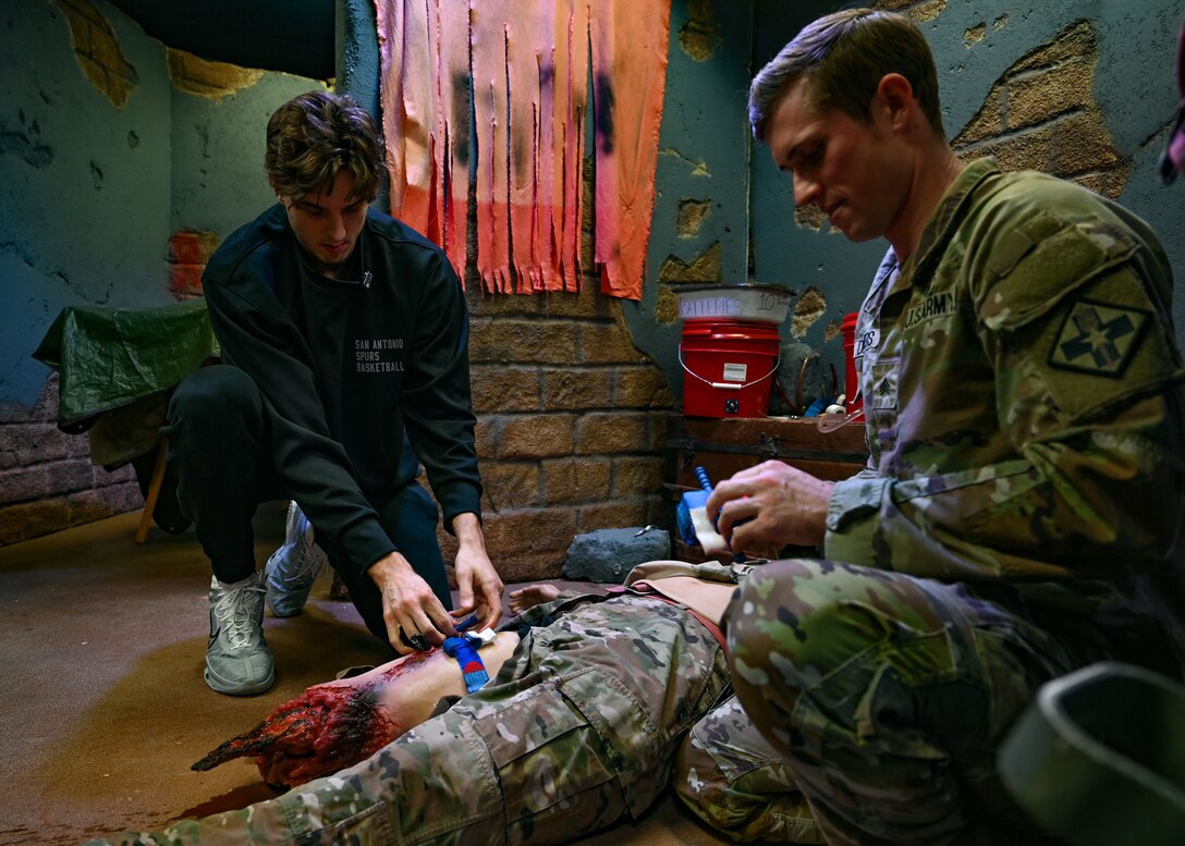 Zach Collins, San Antonio Spurs player, receives tourniquet application training from Army Sgt. Aaron Detmers, Medical Education and Training Campus Combat Medic Specialist Training Program instructor, Jan. 25, 2024, at METC, Joint Base San Antonio-Fort Sam Houston, TX.