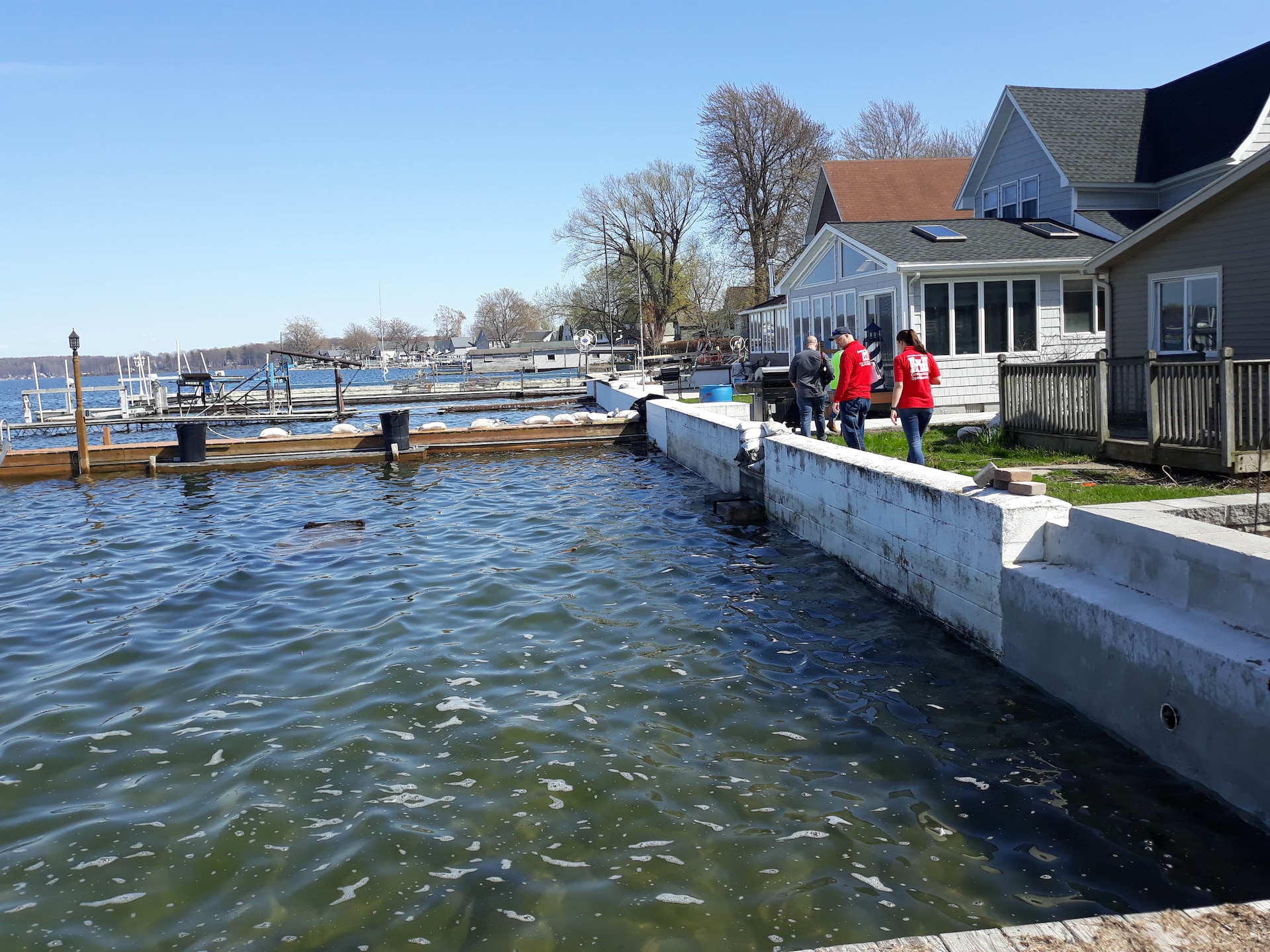 People walk along the shoreline of Lake Ontario in Sodus, N.Y.