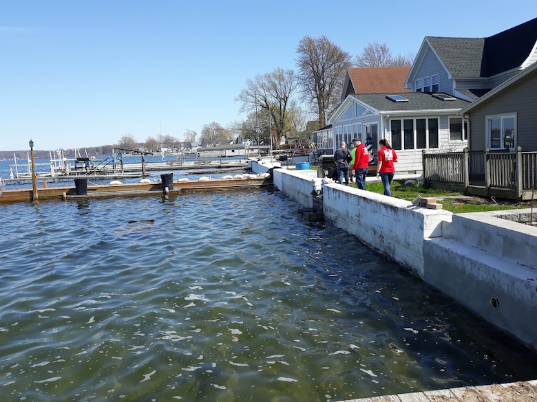 People walk along the shoreline of Lake Ontario in Sodus, N.Y.
