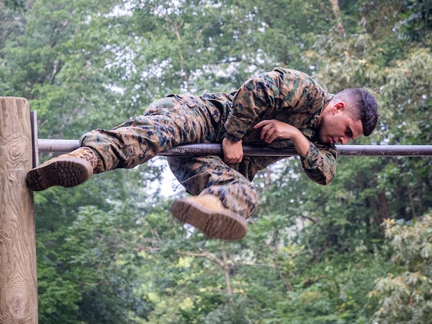 U.S. Marine with Marine Corps Embassy Security Group maneuvers over a bar on an obstacle course during a culminating event of a Marine Corps Martial Arts Program course on Marine Corps Base Quantico, VA., June 30, 2023. The culminating event included a 3-mile hike to the obstacle course, completing the obstacle course three times, a squad competition on the obstacle course, pugil stick combat, completing the endurance course, shallow water grappling, and a 3-mile hike back to the MSAU facility. (U.S. Marine Corps photo by Sgt. Ramon Garcia)