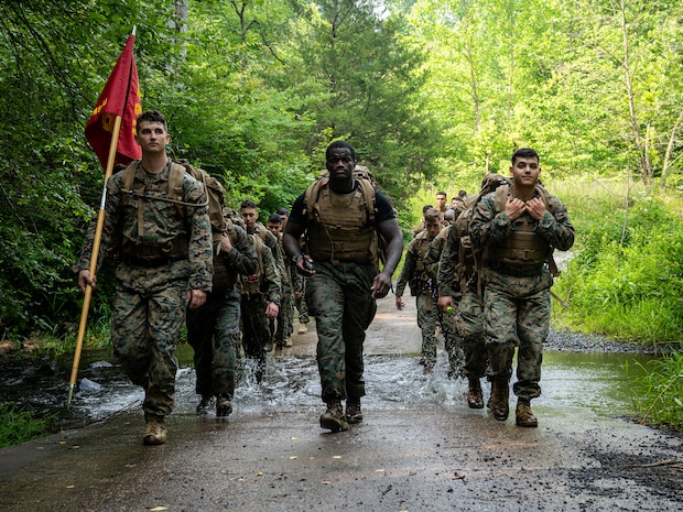 U.S. Marines with Marine Corps Embassy Security Group and Marine Security Guard Security Augmentation Unit hike during a culminating event of a Marine Corps Martial Arts Program course on Marine Corps Base Quantico, VA., June 30, 2023. The culminating event included a 3-mile hike to the obstacle course, completing the obstacle course three times, a squad competition on the obstacle course, pugil stick combat, completing the endurance course, shallow water grappling, and a 3-mile hike back to the MSAU facility. (U.S. Marine Corps photo by Sgt. Ramon Garcia)
