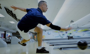 A bowler throws a ball down a lane