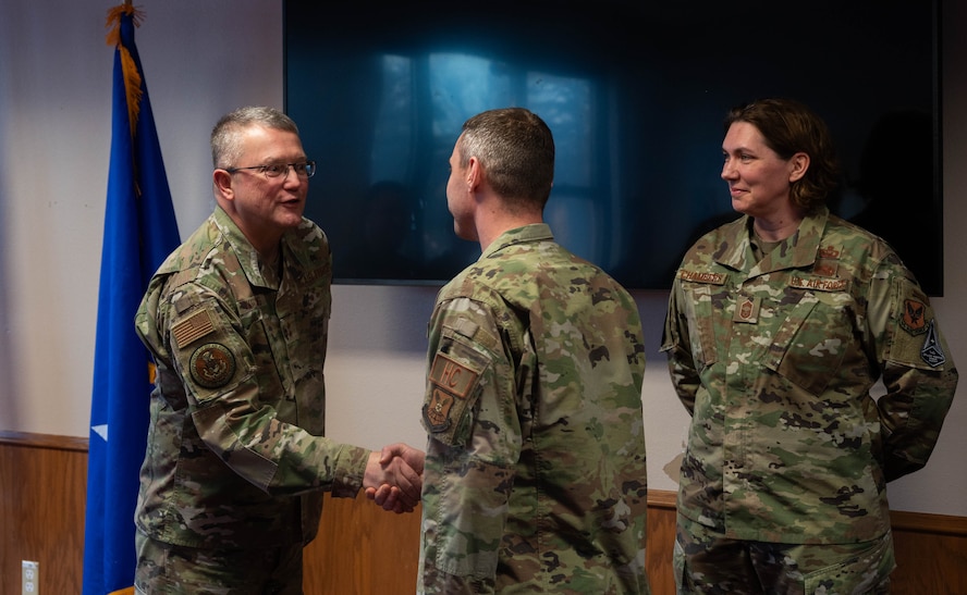 U.S. Air Force Chaplain Maj. Gen. Randall Kitchens, U.S. Air Force chief of chaplains, (left) coins U.S. Air Force Master Sgt. Jacob Schulze, 5th Bomb Wing chaplain, as U.S. Air Force Chief Master Sgt. Sadie Chambers, Religious Affairs senior enlisted advisor, (right) looks on at Minot Air Force Base, North Dakota, Jan. 29, 2024. As the Chief of Chaplains, Kitchens leads the Department of the Air Force Chaplain Corps of approximately 2,100 chaplains and religious affairs Airmen from the active duty and Air Reserve components. (U.S. Air Force photo by Airman 1st Class Luis Gomez)