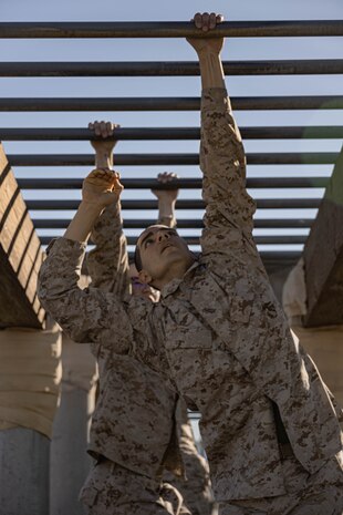U.S. Marine Corps Recruit Gabriel Gomez with Hotel Company, 2nd Recruit Training Battalion, hangs from an obstacle during the confidence course at Marine Corps Recruit Depot San Diego, California, Jan. 29, 2024. The course is designed to challenge the recruits’ physical agility and mental focus by completing obstacles that require their strength, balance, and determination.  Gomez is a native of Farmington, New Mexico. (U.S. Marine Corps photo by Lance Cpl. Alexandra M. Earl)