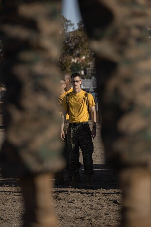 U.S. Marine Corps Staff Sgt. Thomas Brucia, a Stockdale, California native and a senior drill instructor with Hotel Company, 2nd Recruit Training Battalion, demonstrates warm-up exercises before the confidence course at Marine Corps Recruit Depot San Diego, California, Jan. 29, 2024. The course is designed to challenge the recruits’ physical agility and mental focus by completing obstacles that require their strength, balance, and determination.  (U.S. Marine Corps photo by Lance Cpl. Alexandra M. Earl)