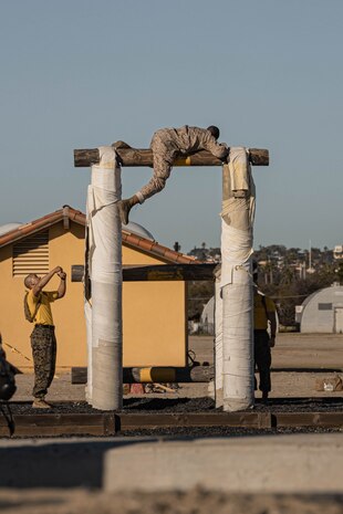U.S. Marine Corps Recruit Christian Raymond with Hotel Company, 2nd Recruit Training Battalion, climbs over an obstacle during the confidence course at Marine Corps Recruit Depot San Diego, California, Jan. 29, 2024. The course is designed to challenge the recruits’ physical agility and mental focus by completing obstacles that require their strength, balance, and determination. Raymond is a native of Houston. (U.S. Marine Corps photo by Lance Cpl. Alexandra M. Earl)
