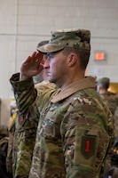 U.S. Army Soldier salutes the flag during the national anthem during the DIVARTY Alignment Ceremony at King Field House on Fort Riley, Kansas, Jan. 19, 2024. The national anthem is played during military ceremonies as a time-honored tradition. (U.S. Army photo by Spc. Mackenzie Striker)