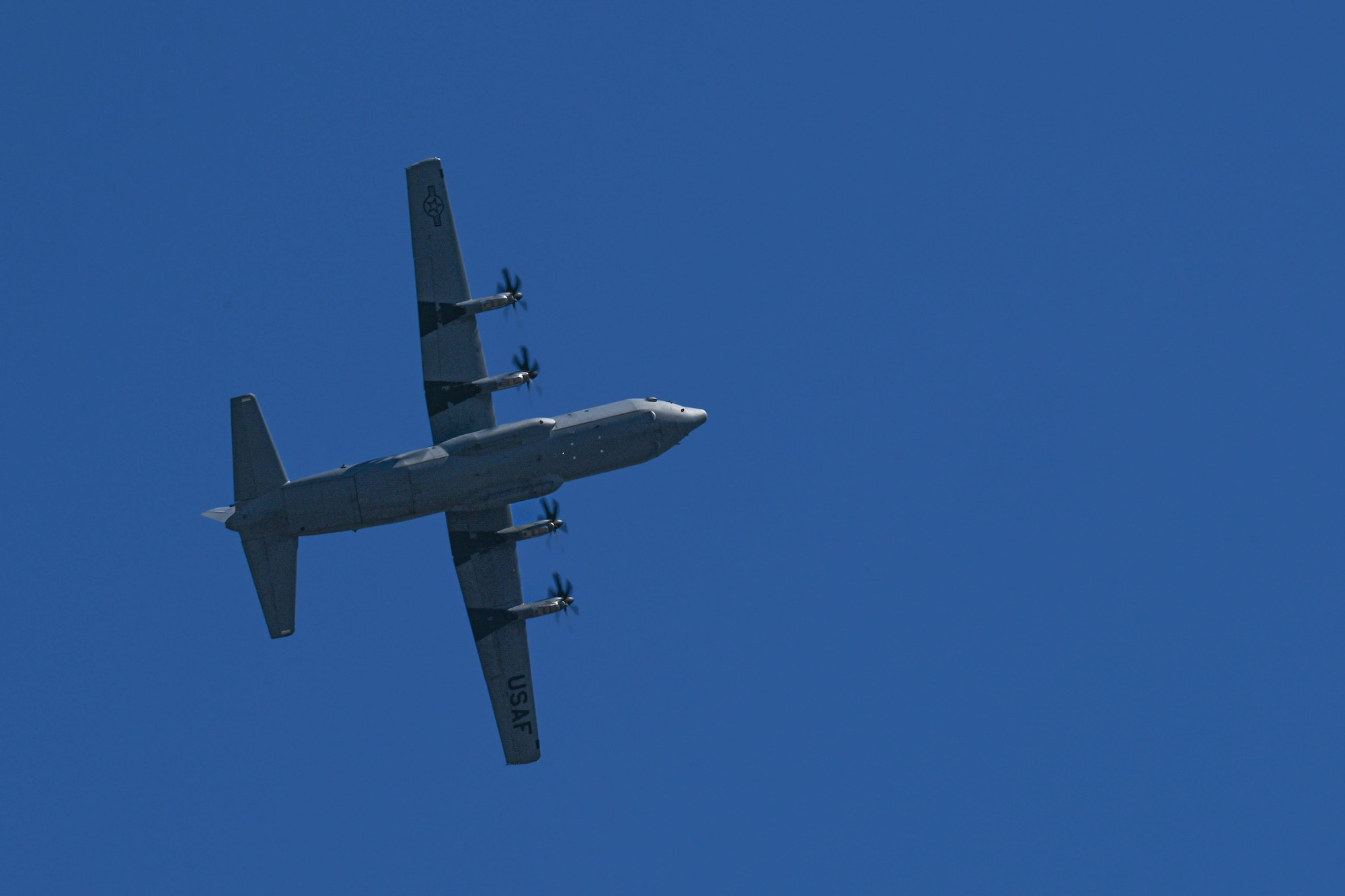 A C-130 flies in the sky.