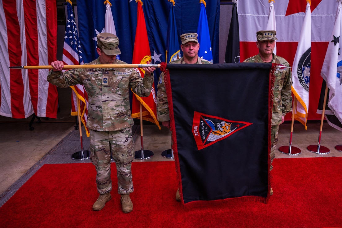 U.S. Space Force Chief Master Sgt. Grange S. Coffin, U.S. Space Forces-Space (S4S) senior enlisted leader, U.S. Space Force Chief of Space Operations Gen. Chance Saltzman, and Lt. Gen. Douglas A. Schiess, S4S commander and the Combined Joint Force Space Component Commander, ceremonially unfurl the S4S flag during a ceremony at Vandenberg Space Force Base, Calif., Jan. 31, 2024. Previously, Space Operations Command was assigned to U.S. Space Command as the Space Force service component, but this realignment of service component responsibilities under S4S optimizes force presentation for mission readiness. (U.S. Space Force photo by Tech. Sgt. Luke)