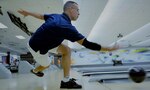 A bowler throws a ball down a lane