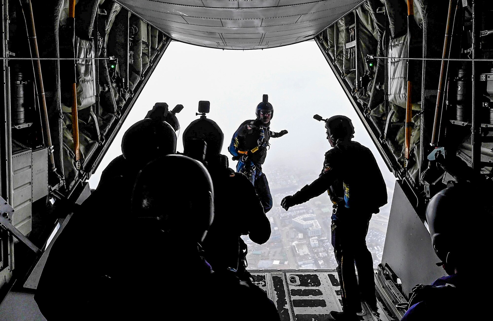 Men jump out of a plane.