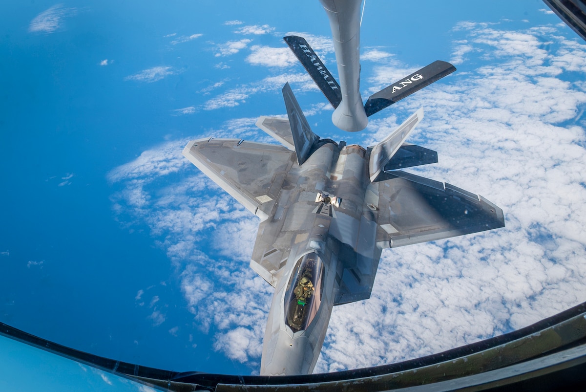 A military aircraft is being refueled in air.