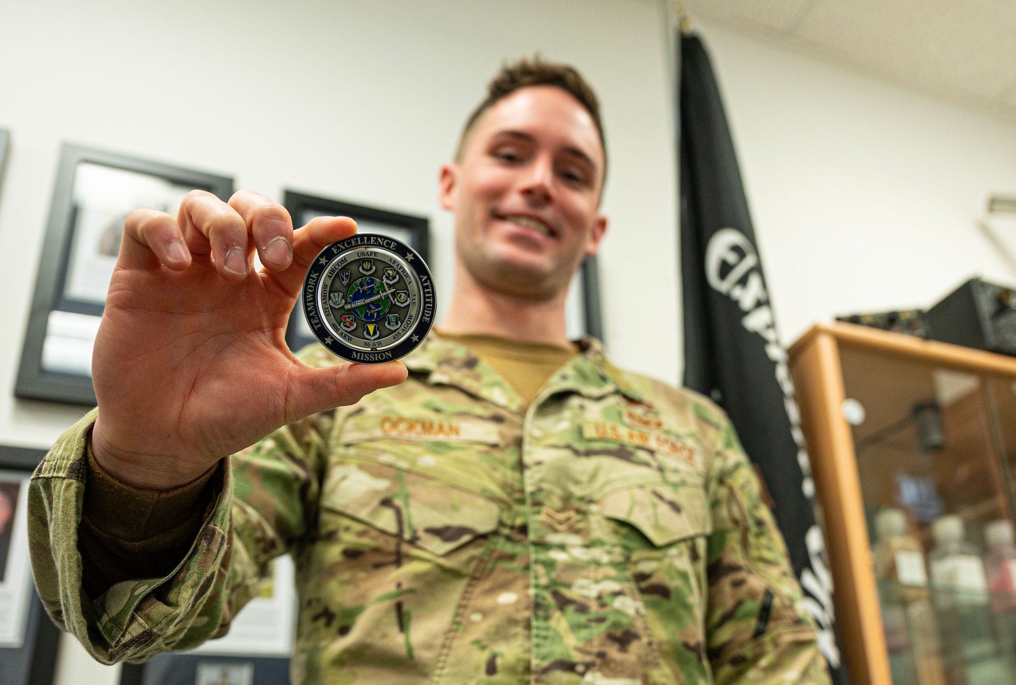 U.S. Air Force Airman 1st Class Kelsey Ockman, 786th Civil Engineer Squadron Explosive Ordnance Disposal apprentice, holds a challenge coin he earned at Ramstein Air Base, Germany, Jan. 30, 2024. Ockman credits his success to his team who he says are his inspiration and is proud to serve with. (U.S. Air Force photo by Senior Airman Thomas Karol)