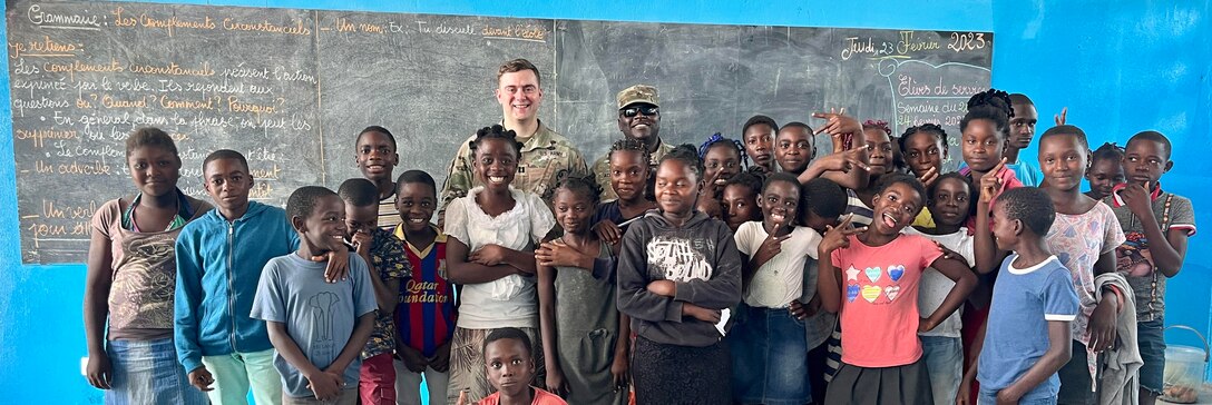 U.S. Army Corps of Engineers, Europe District Project Engineer Capt. Ben Ketchum and Staff Sgt. Ed Achana with the U.S. Libreville Embassy Office of Security Cooperation pose with local Gabonese school children at the recently renovated Mabanda Primary School February 23, 2023. Ketchum supports humanitarian assistance projects like this in several countries in Europe and Africa as an Army engineer with the U.S. Army Corps of Engineers, Europe District and has said a large part of what drove him to join the Army was his desire to serve others and help communities all over the world. (Courtesy photo)
