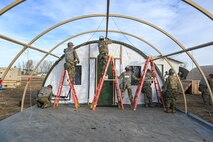 Airmen installing a tent