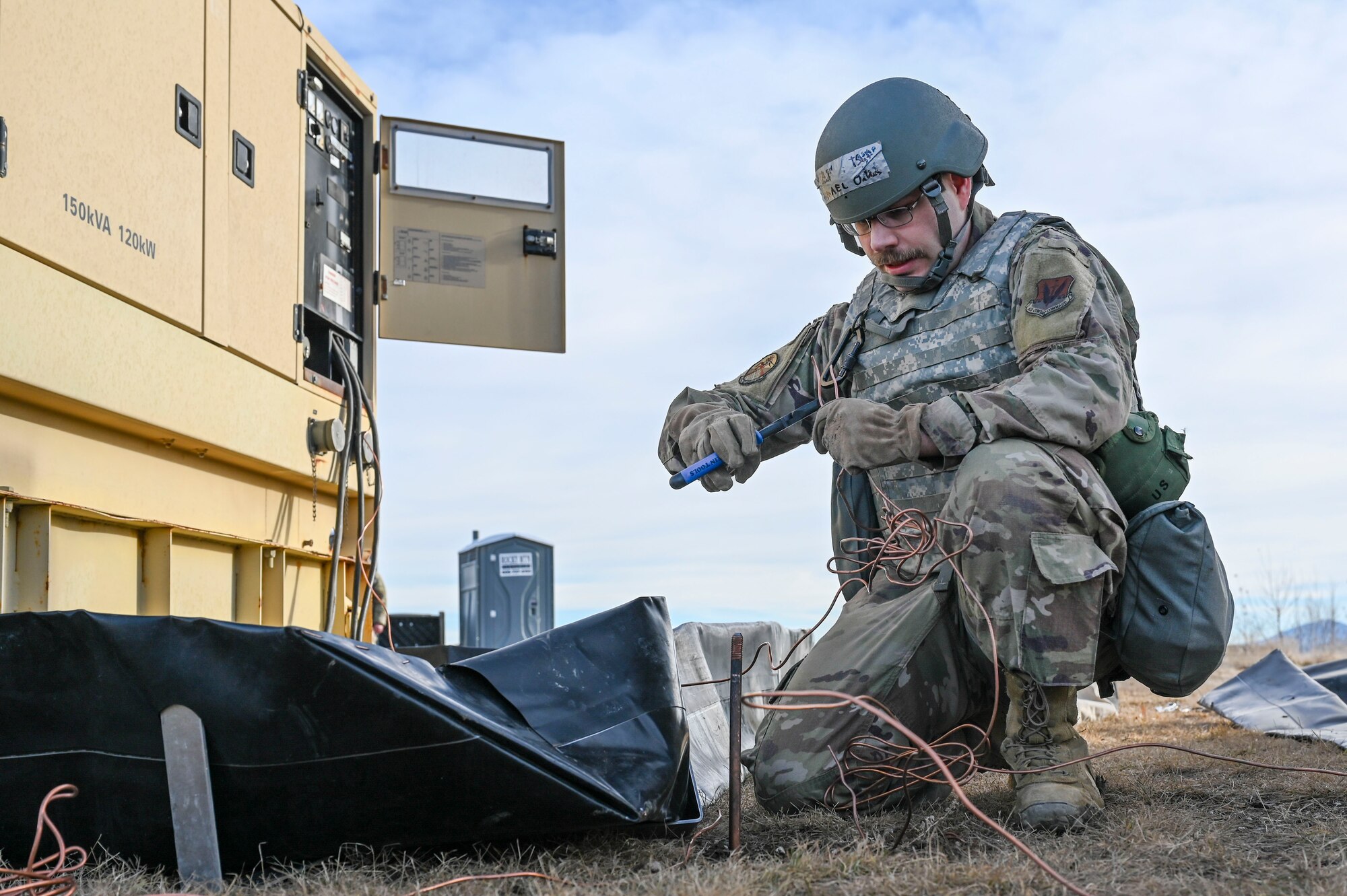 An Airman cutting a piece of copper wire.