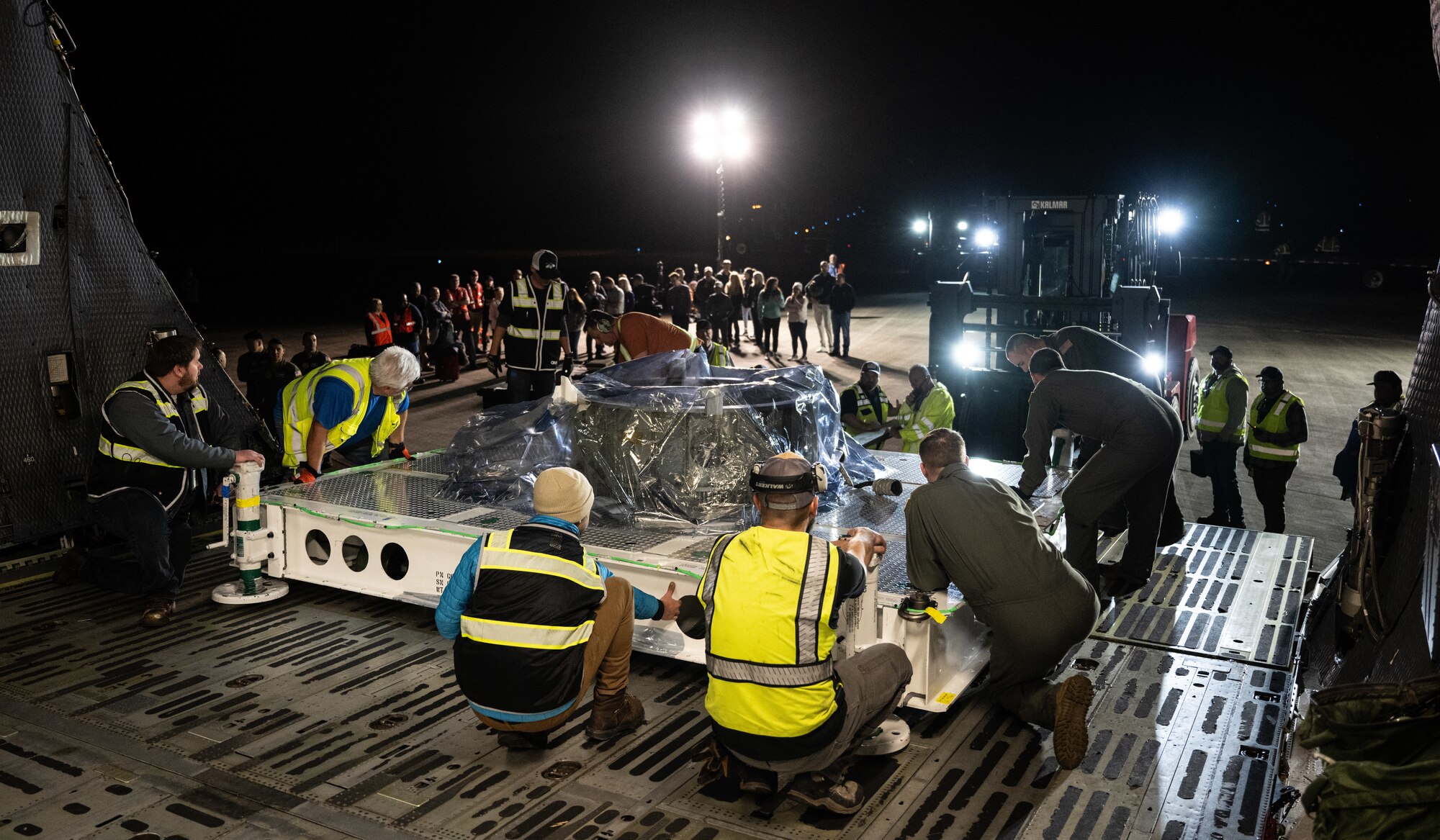 U.S. Airmen assigned to the 9th Airlift Squadron and Lockheed Martin crew members offload National Oceanic and Atmospheric Administration Geostationary Operational Environmental Satellite support cargo from a U.S. Air Force C-5M Super Galaxy at NASA Kennedy Space Center on Merritt Island, Florida, Jan. 23, 2024. The 9th AS aircrew transported NOAA’s newest weather satellite, GOES-U, to Kennedy Space Center from Buckley Space Force Base, Colorado, using its oversized carrying capacity as the largest mobility aircraft in the Air Force’s inventory. (U.S. Air Force photo by Staff Sgt. Marco A. Gomez)