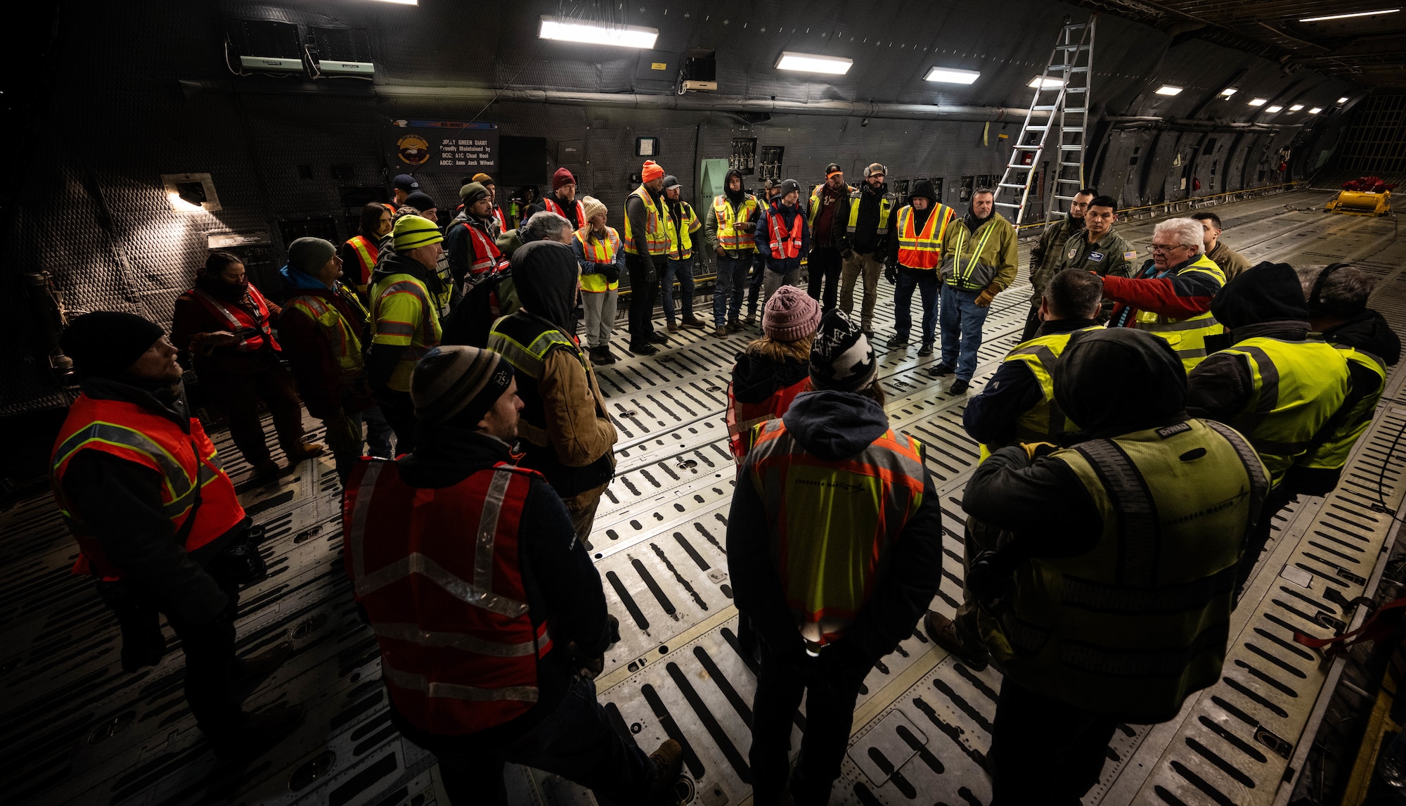U.S. Airmen assigned to the 9th Airlift Squadron and Lockheed Martin crew members listen to a brief prior to loading a National Oceanic and Atmospheric Administration Geostationary Operational Environmental Satellite onto a C-5M Super Galaxy at Buckley Space Force Base, Colorado, Jan. 22, 2024. GOES-U, the final spacecraft in the GOES-R series of weather and climate satellites, will be transported by 9th AS aircrew to NASA’s Kennedy Space Center ahead of its scheduled launch in April 2024. (U.S. Air Force photo by Staff Sgt. Marco A. Gomez)