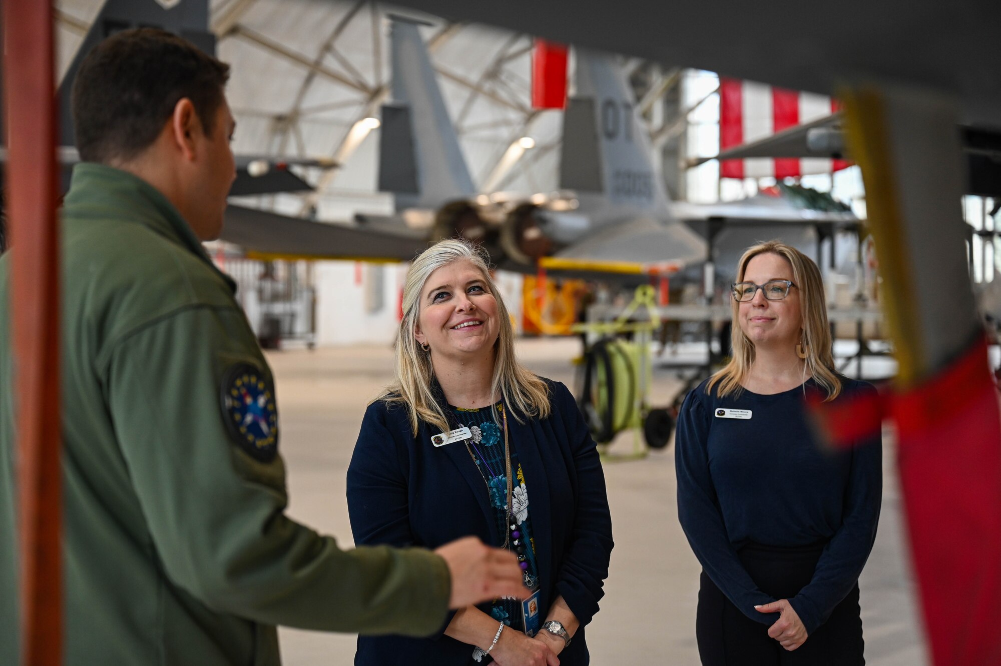 U.S. Air Force Maj. Seth Brown, 350th Spectrum Warfare Wing commander’s action group chief, briefs Amy Klugh, 87th Electronic Warfare Squadron honorary commander, left, and Melanie Moore, 16th EWS honorary commander, right, on the F-15E Strike Eagle during a tour at Eglin Air Force Base, Fla., Jan. 25, 2024. On the tour, Honorary Commanders were briefed on each of the units’ missions for the wing and shown statics of the F-15E Strike Eagle and F-15EX Eagle II. (U.S. Air Force photo by Capt. Benjamin Aronson)
