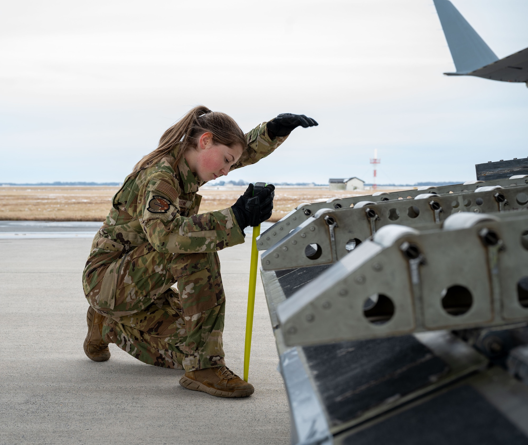 U.S. Air Force Airman 1st Class Alexandra Shaddow, 3rd Airlift Squadron loadmaster, motions to lower the ramp of a C-17 Globemaster III during combat offload Method C testing at Dover Air Force Base, Delaware, Jan. 23, 2024. The new combat offload Method C would allow C-17s to deliver cargo without the assistance of any material handling equipment. (U.S. Air Force photo by Airman 1st Class Amanda Jett)