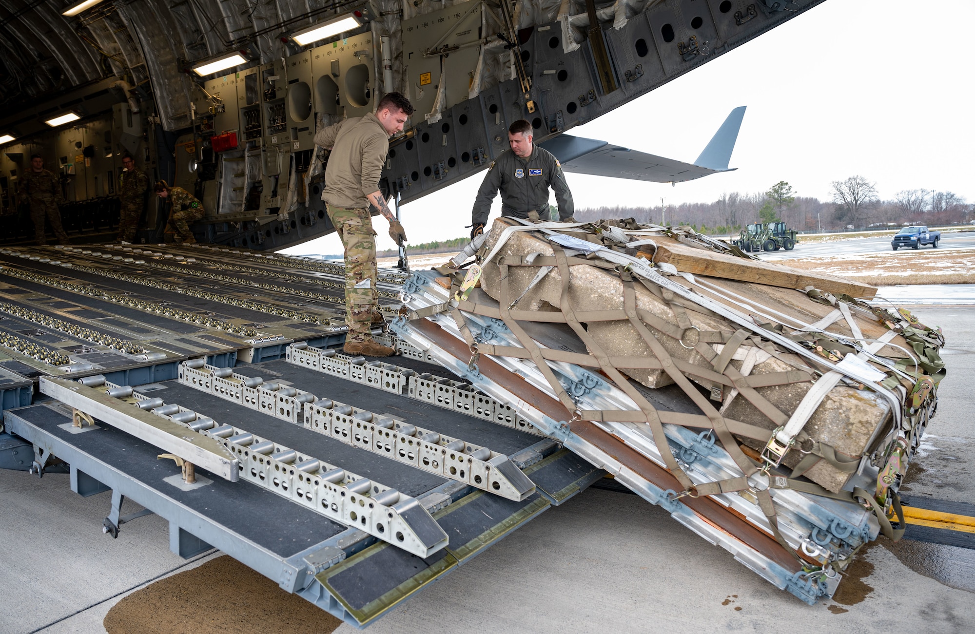 U.S. Air Force Staff Sgt. Jared Soucy, 3rd Airlift Squadron loadmaster, adjusts the winch on a C-17 Globemaster III during combat offload Method C testing at Dover Air Force Base, Delaware, Jan. 23, 2024. The new combat offload Method C would allow C-17s to deliver cargo without the assistance of any material handling equipment. (U.S. Air Force photo by Airman 1st Class Amanda Jett)
