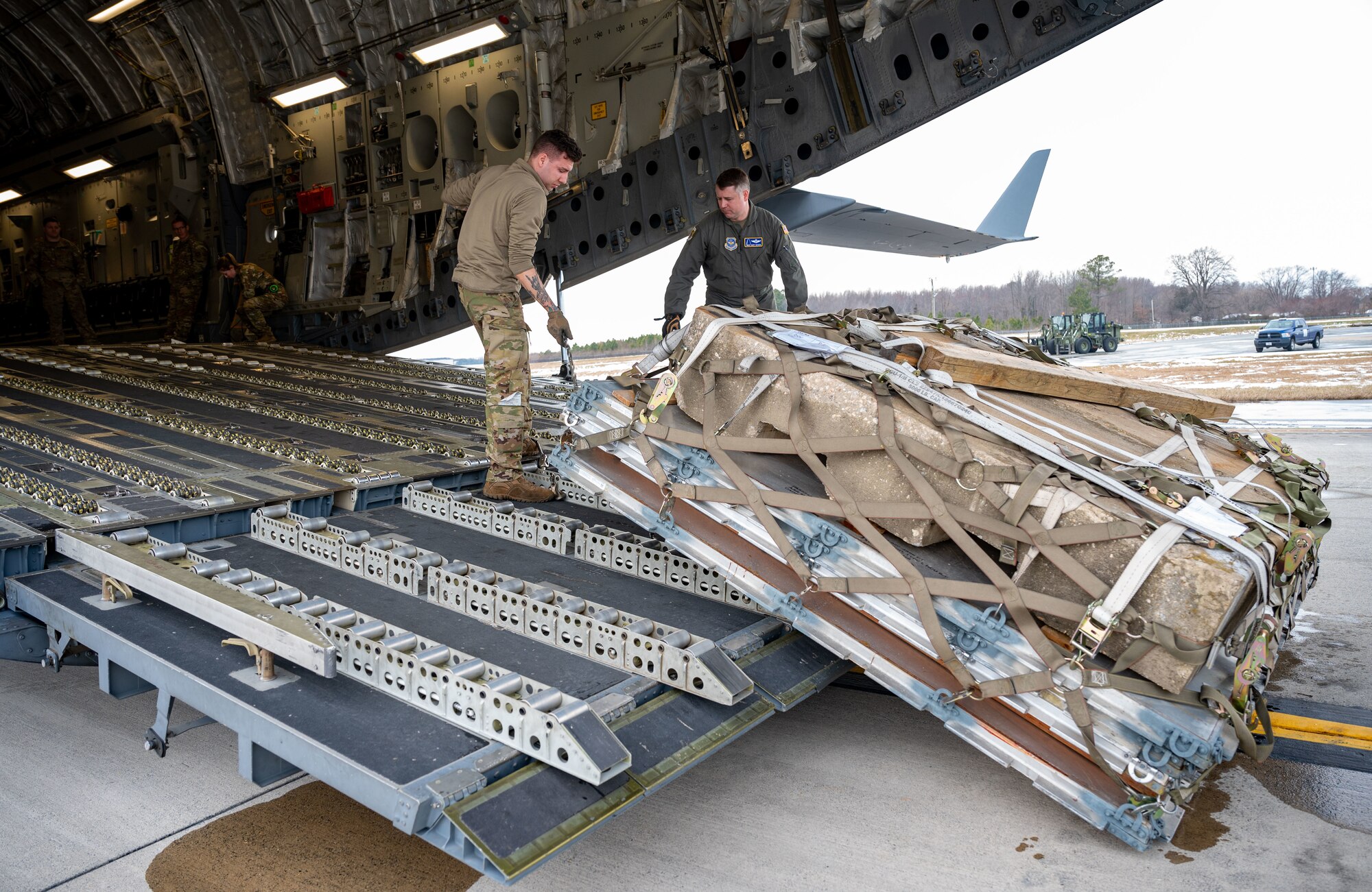 U.S. Air Force Staff Sgt. Jared Soucy, 3rd Airlift Squadron loadmaster, adjusts the winch on a C-17 Globemaster III during combat offload Method C testing at Dover Air Force Base, Delaware, Jan. 23, 2024. The new combat offload Method C would allow C-17s to deliver cargo without the assistance of any material handling equipment. (U.S. Air Force photo by Airman 1st Class Amanda Jett)