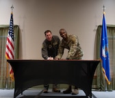 U.S. Air Force Col. Daniel Hoadley, 5th Bomb Wing commander, (left) and U.S. Air Force Col. Kenneth McGhee, 91st Missile Wing commander, pose before signing the Black History Month (BHM) proclamation at Minot Air Force Base, North Dakota, Feb. 1, 2024. It is a yearly tradition for the commanders at Minot AFB to sign a proclamation signifying the official start of Black History Month. (U.S. Air Force Photo by Airman 1st Class Luis Gomez)