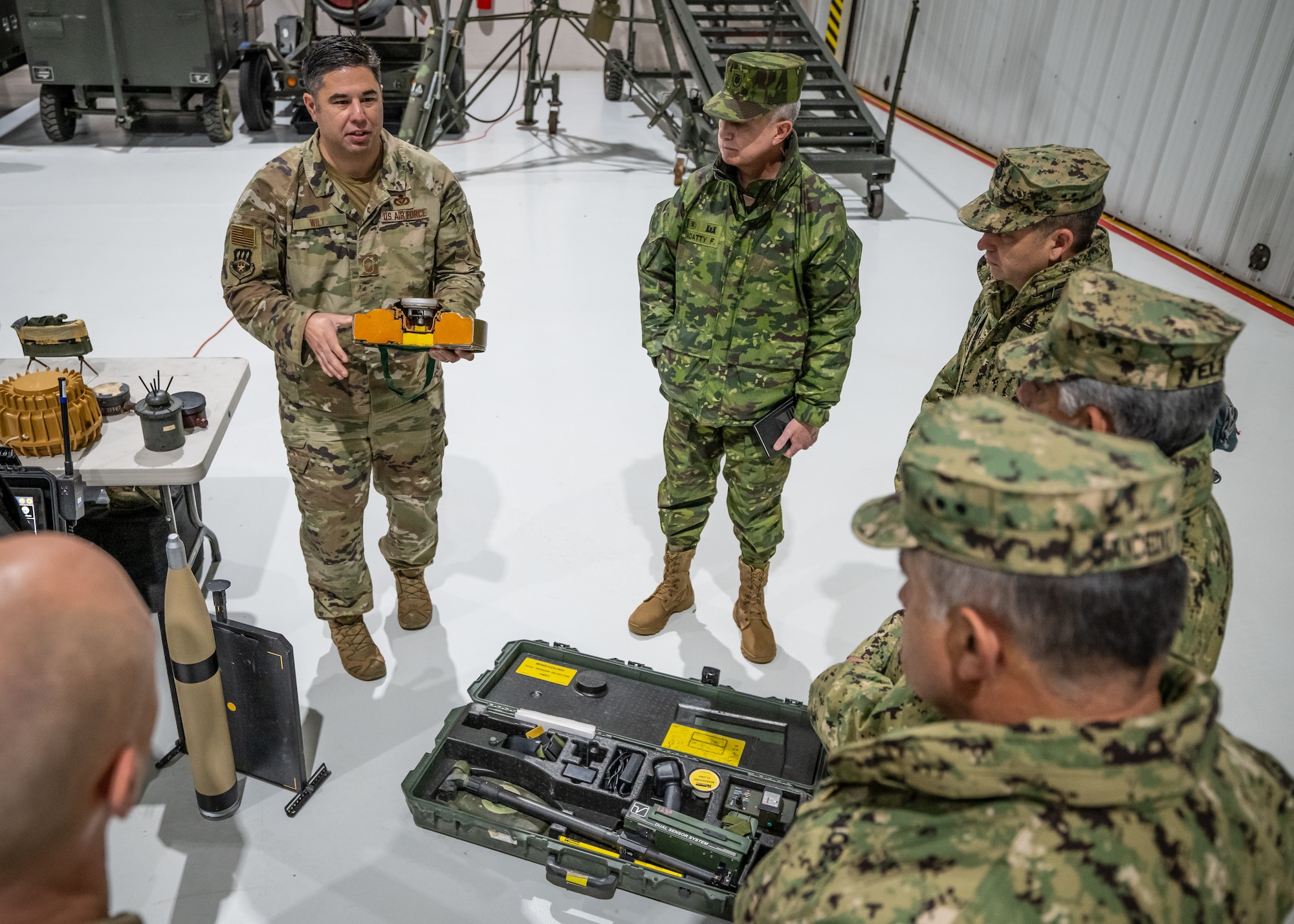 U.S. Air Force Chief Master Sgt. Matthew Wilt, left, superintendent of the Kentucky Air National Guard’s 123rd Explosive Ordnance Disposal Flight, discusses mine detection equipment with Ecuadorian military leaders at the Kentucky Air National Guard Base in Louisville, Ky., Jan. 31, 2024. The Ecuadorians are visiting this week to exchange information with the Kentucky National Guard as part of the State Partnership Program, a National Guard Bureau effort that pairs Guard units with foreign allies to foster enhanced understanding across all aspects of civil and military affairs. (U.S. Air National Guard photo by Dale Greer)