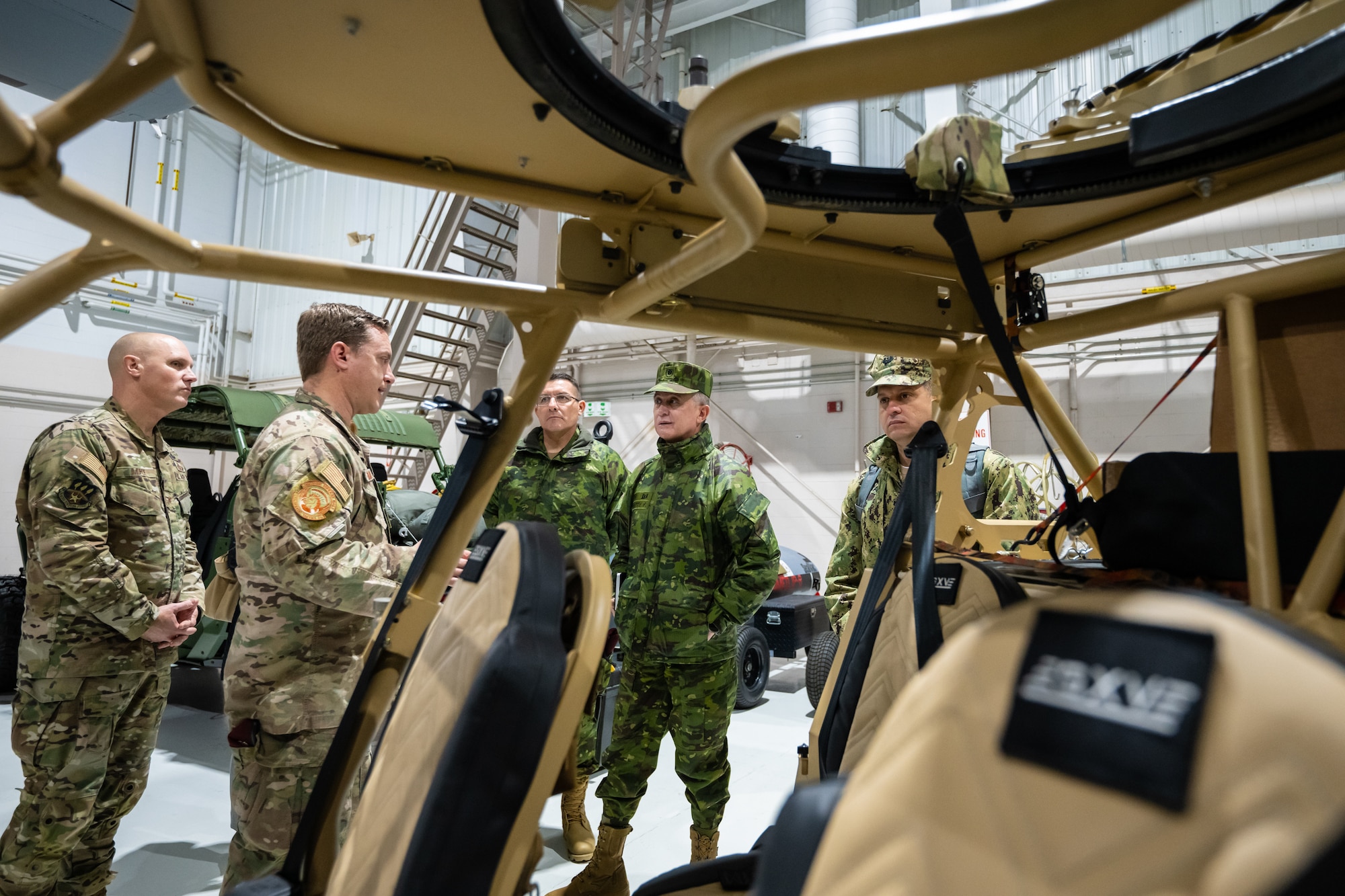 U.S. Air Force Senior Master Sgt. Blair Baerny, second from left, a pararescuman assigned to the Kentucky Air National Guard’s 123rd Special Tactics Squadron, discusses tactical vehicles with Ecuadorian military leaders at the Kentucky Air National Guard Base in Louisville, Ky., Jan. 31, 2024. The Ecuadorians are visiting this week to exchange information with the Kentucky National Guard as part of the State Partnership Program, a National Guard Bureau effort that pairs Guard units with foreign allies to foster enhanced understanding across all aspects of civil and military affairs. (U.S. Air National Guard photo by Dale Greer)