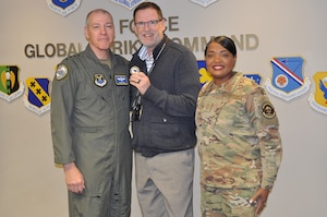 From left, Gen. Thomas Bussiere, commander of Air Force Global Strike Command; Andrew Robinson, logistics programmer in AFGSC’s A4 Directorate; and Chief Master Sgt. Melvina Smith, command chief of AFGSC, pose together for a photo at Barksdale Air Force Base, Louisiana, Dec. 18, 2023. Robinson was coined by Bussiere and recognized by AFGSC leadership for his years of outstanding performance in the command’s Weapon Systems Sustainment Branch managing helicopter maintenance, services and acquisition contracts for the command and the Air Force as well as being the Department of the Air Force’s Outstanding Air Force Services Program Manager of the Year in 2022. (U.S. Air Force Courtesy Photo)