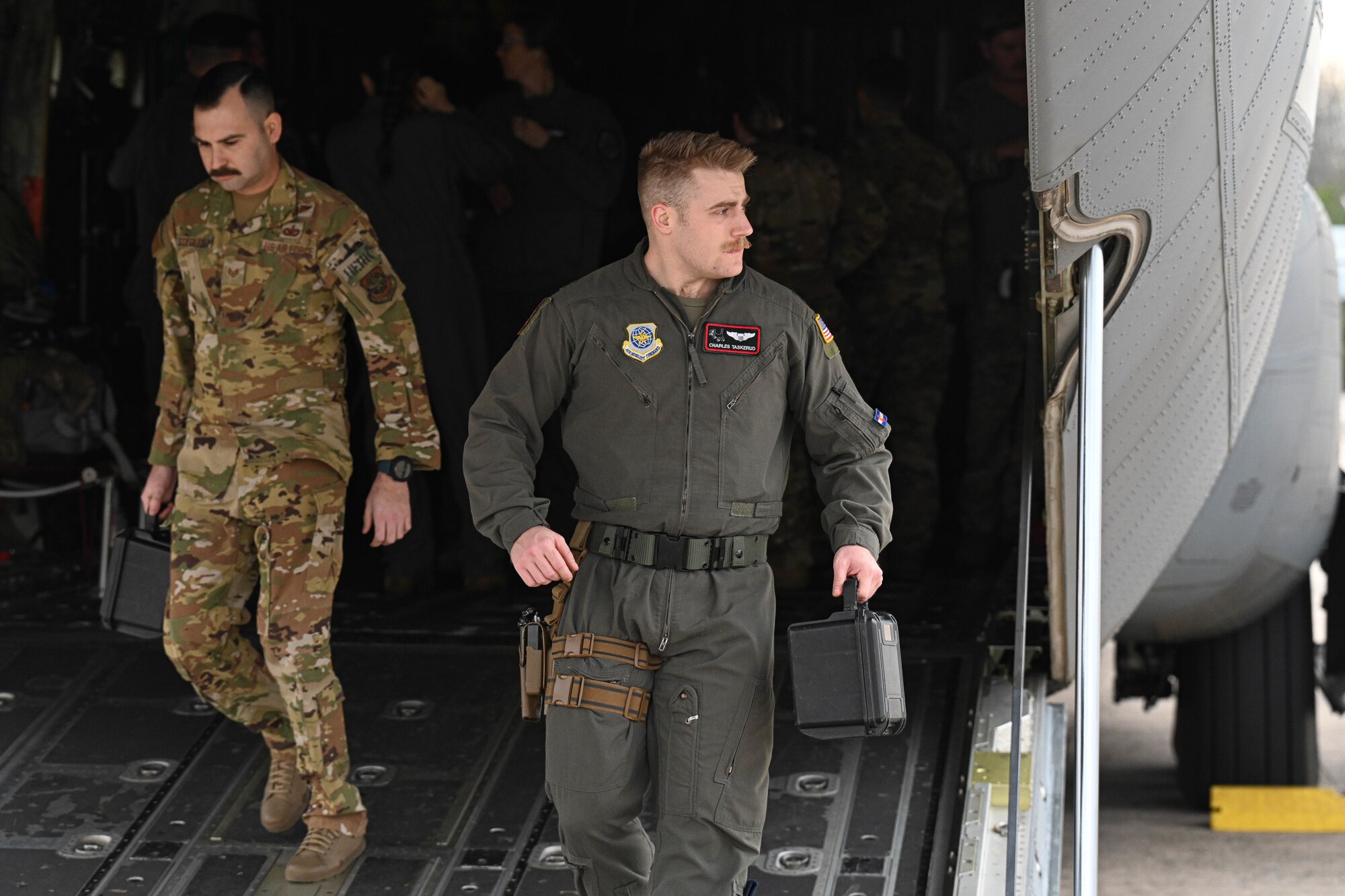 An Airman walks out of a C-130.
