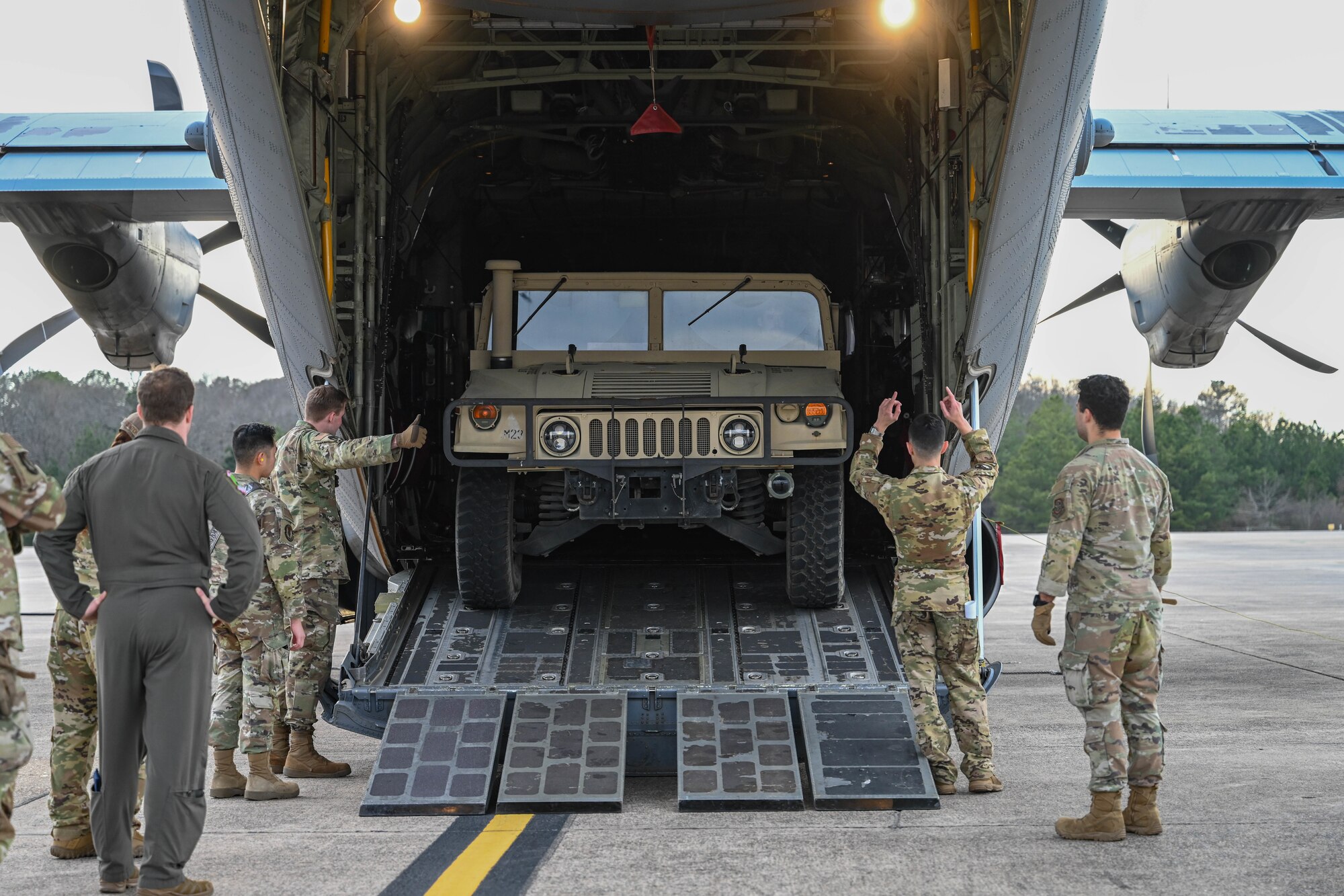 Airmen load a Humvee onto a C-130.