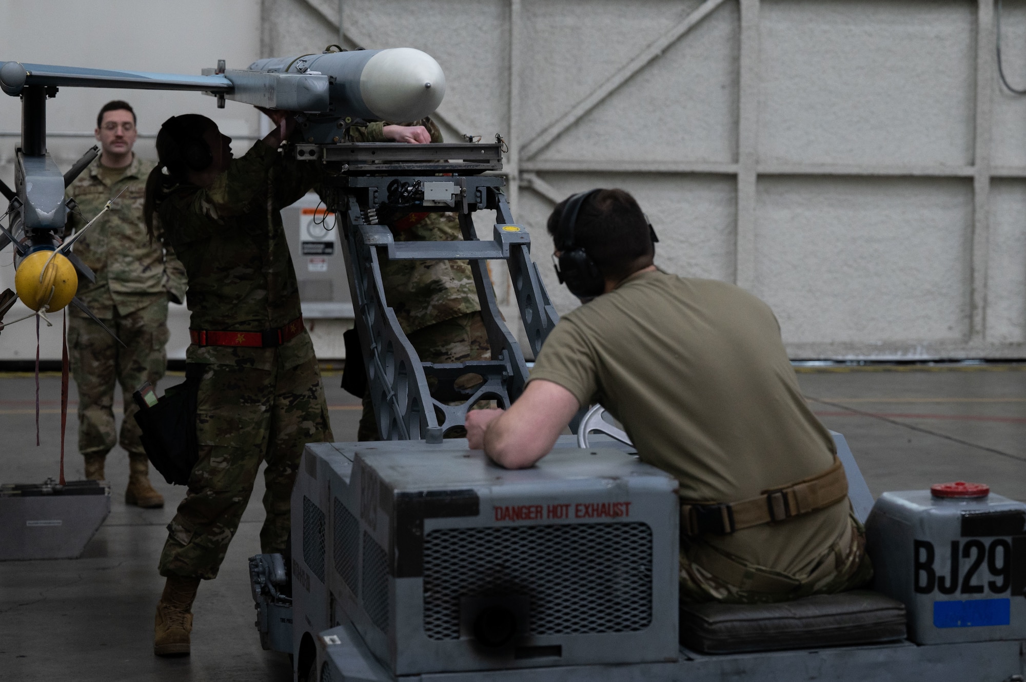 U.S. Air Force Airmen, 18th Aircraft Maintenance Unit, load a piece of munition on Eielson Air Force Base, Alaska, Jan. 29, 2024.