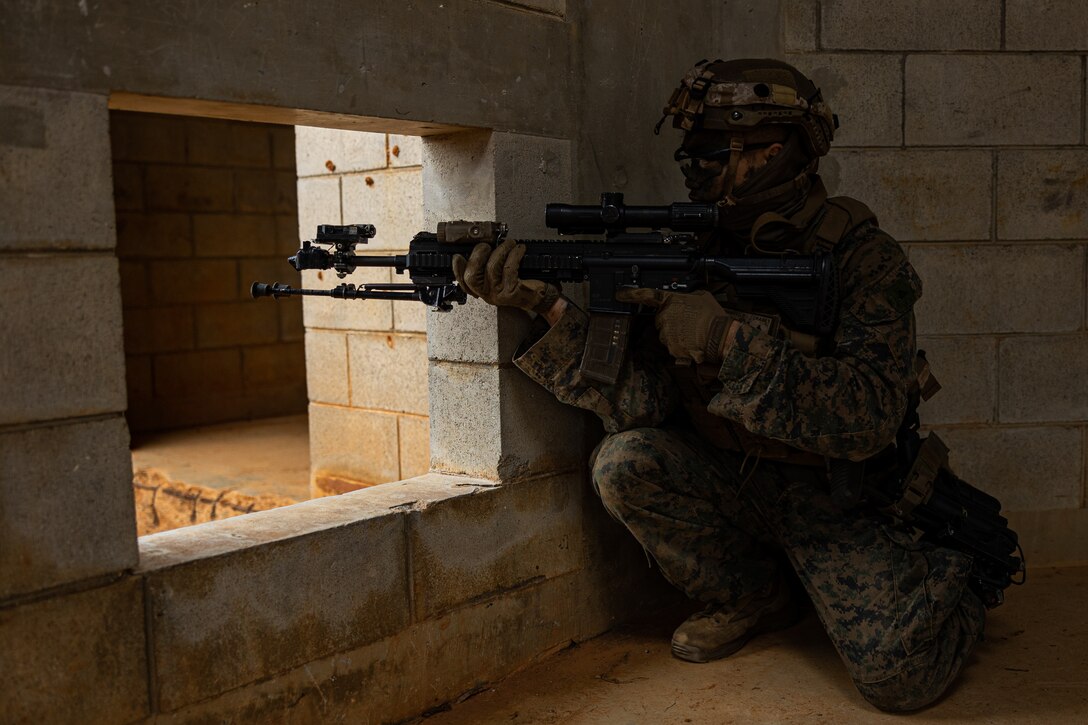 A U.S. Marine posts security after clearing a building during the 3d Marine Division Squad Competition at Camp Hansen, Okinawa, Japan, Jan. 24, 2024. The competition tested the Marines across various combat-related tasks to evaluate each squad’s tactical proficiency, mental and physical endurance, and decision-making skills to determine the Division’s most proficient and capable rifle squad. The Marine is with 3d Littoral Combat Team, 3d Marine Littoral Regiment, 3d Marine Division. (U.S. Marine Corps photo by Cpl. Eduardo Delatorre)